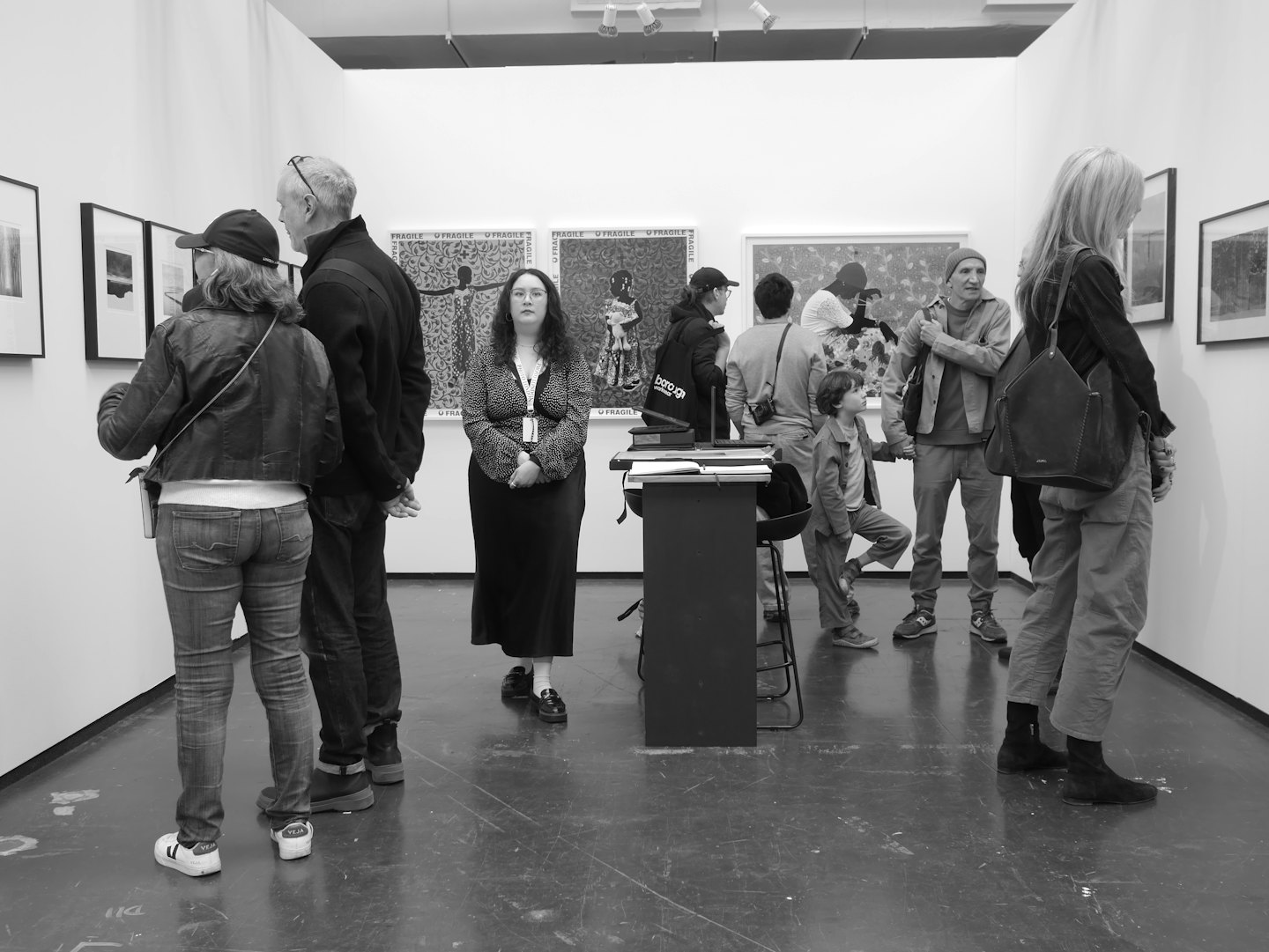 Persone ammirano opere d'arte in una mostra in galleria.